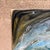 For your consideration, a blue and gold fluid art painting on board featuring resin and crushed glass, commonly...