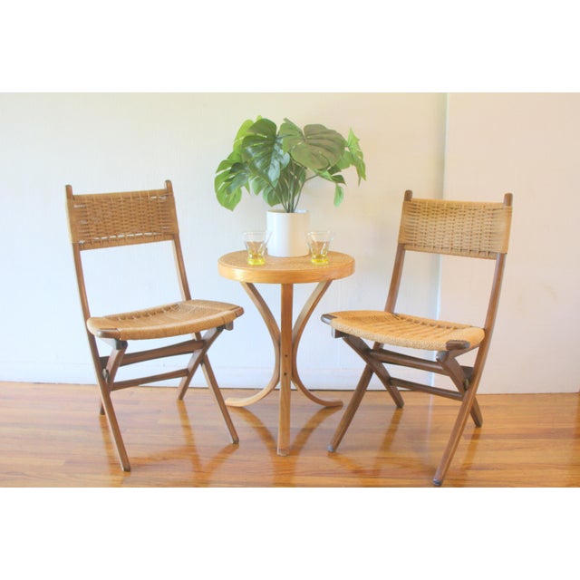 This is a pair of mid century modern Hans Wegner style folding chairs with solid wood frames and woven cord seats and...