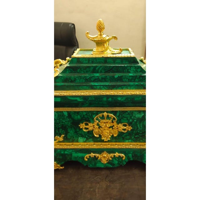 An elegant 20th-century Empire style malachite box, embodying opulence and classical refinement. The box is meticulously...