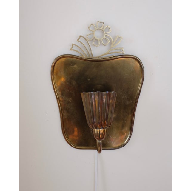 Beautiful 1940s Wall light by Lars Holmström Sweden. Elegantly organic shaped brass with a decorative flower on the top...