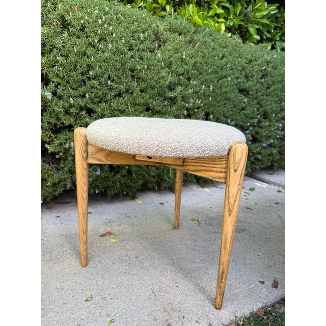 Set of three stackable vintage Danish Modern style upholstered stools featuring softly rounded, cushioned seats in a...