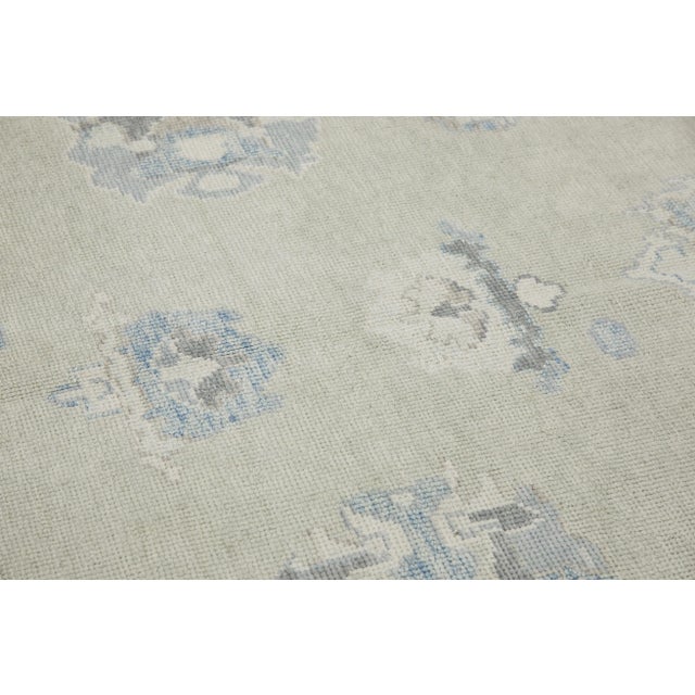 This modern Turkish Oushak rug is a stunning piece of art that has been handwoven using traditional techniques by skilled...