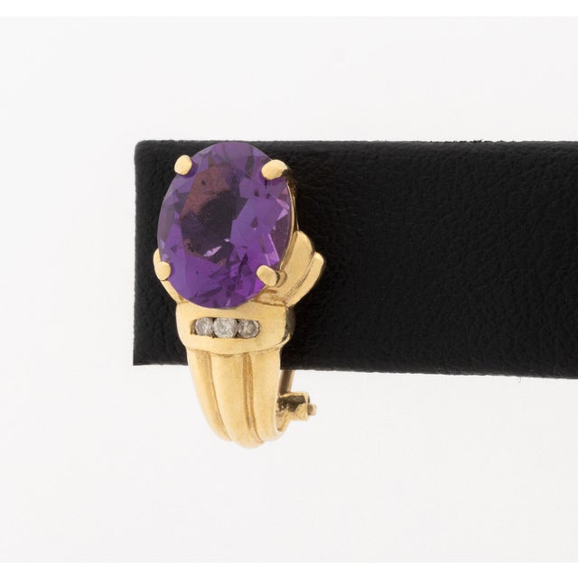 14K Yellow Gold and Amethyst Diamond Huggie Earrings, featuring two prong set oval brilliant amethysts weighing approx....