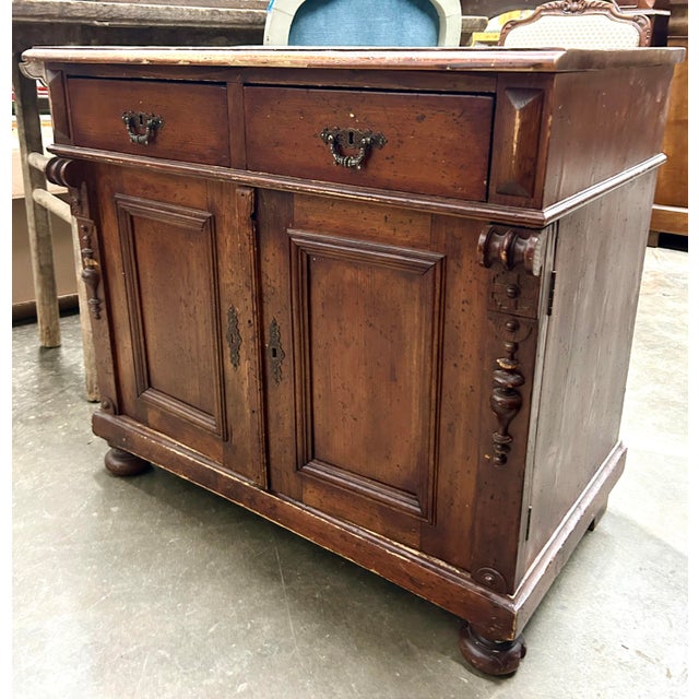 A charming and functional antique eastern European pine sideboard cabinet with original pulls. Offers plenty of storage...