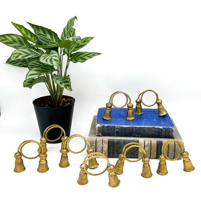 Elegant set of eight brass napkin rings designed as twisted rope loops terminating in classic tassels. Their sculptural...