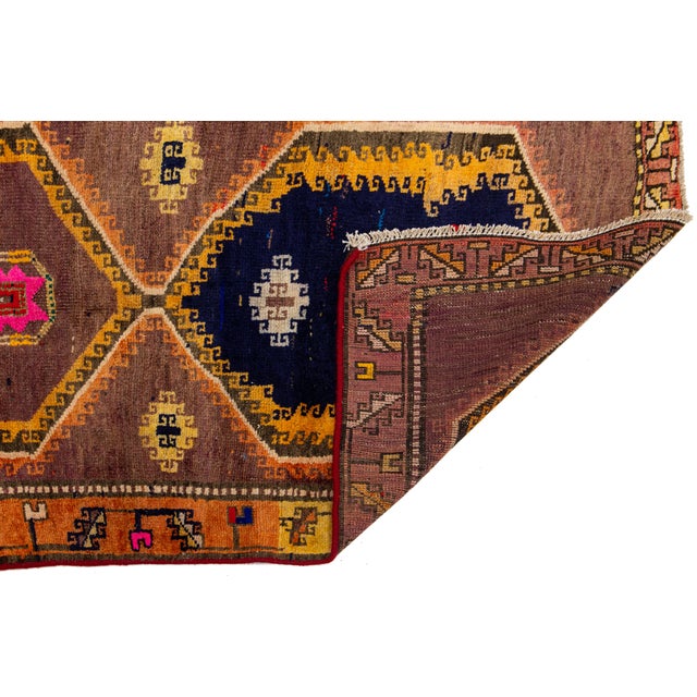This striking vintage Persian runner features a bold, nomadic aesthetic characterized by four large stacked medallions and...