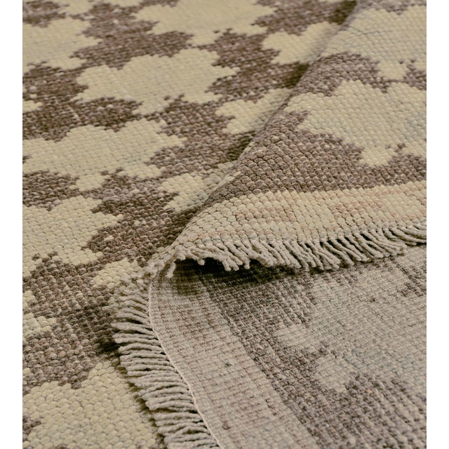 This mid-century Turkish rug has a mole-brown field with diagonal rows of buff-brown bold floral motifs, in a narrow buff-...