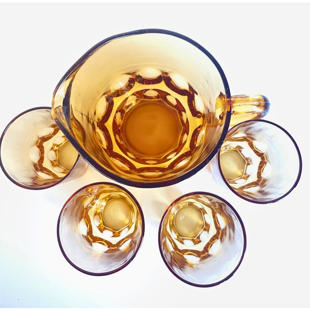 Bring warm mid-century charm to your bar cart or tablescape with this vintage Reflection-Amber pressed glass set by Hazel-...