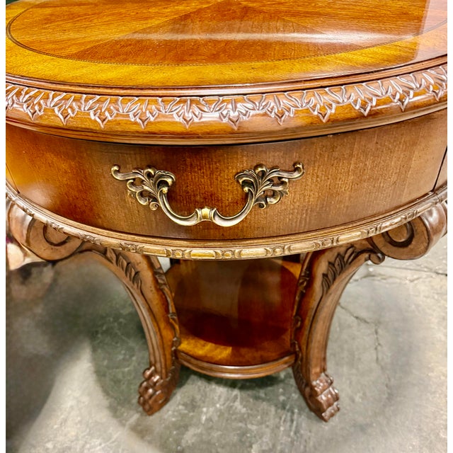 This is a set of three vintage wooden tables consisting of a large oval coffee table and two matching end tables. They...