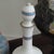 Elegant glass carafe in the Neoclassical style with a white background, red medallion, and antique-style head profile....