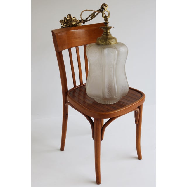 Exquisite large Art Nouveau pendant light with Floral carved glass shade from France 1910. The large glass shade is...