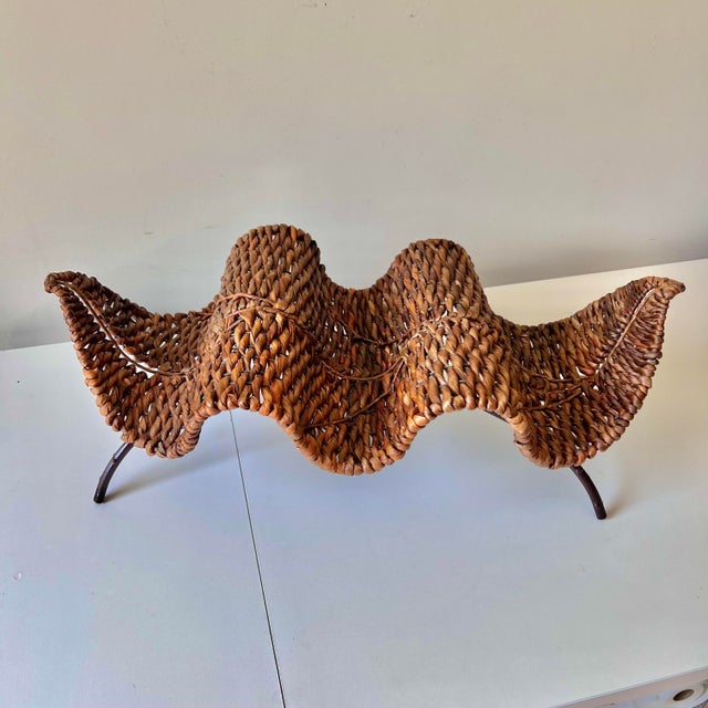 Stunning vintage organic modern rattan leaf and iron wine rack holder. The piece accommodates up to three bottles of wine.