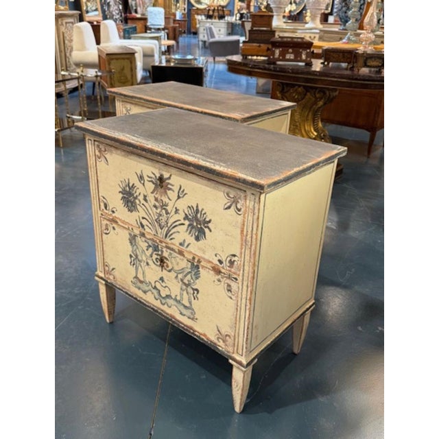 The product is a nice pair of German Neo-Classical style side tables, painted in blue and white. The Neo-Classical style...