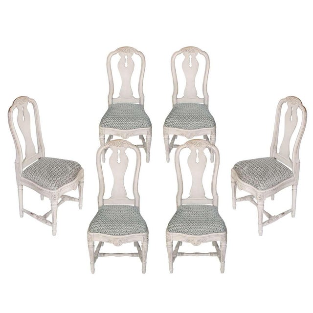 This elegant set of six dining chairs features classic Queen Anne styling with pierced splats, floral carvings, and...
