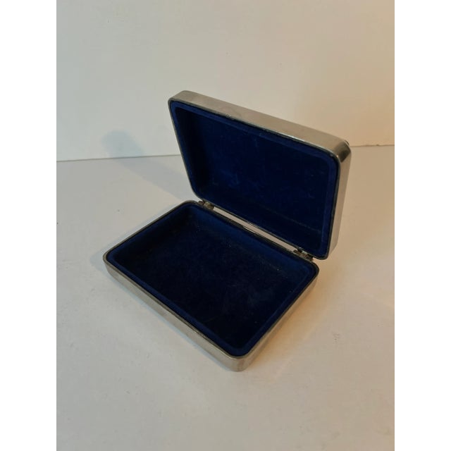 A beautiful silver plate box with edge detail and blue velvet interior