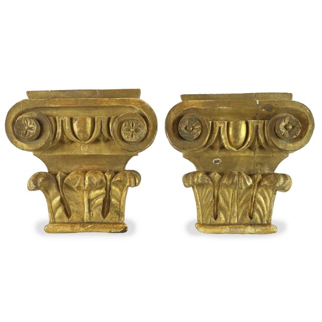 A pair of gilded poplar capitals from the 1800s, originally part of a larger decorative ensemble. In a composite style,...