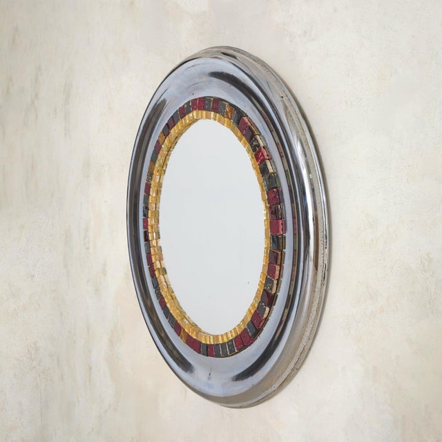 A French round wall mirror from the 1970s, defined by contrast, color, and a distinctly graphic sense of composition. The...