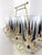 Mid-century modern bar set featuring eight highball glasses housed in a brass-toned carrier. Each glass is decorated with...