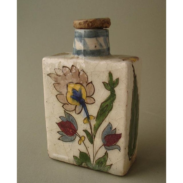 Early Qajar pottery tea flask with lid. Made of a composite clay with a grit paste, decorated with a sketchy floral design...