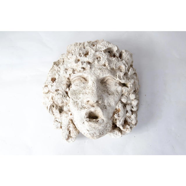 Wonderfully weathered Medusa mask in cast stone as a garden ornament.