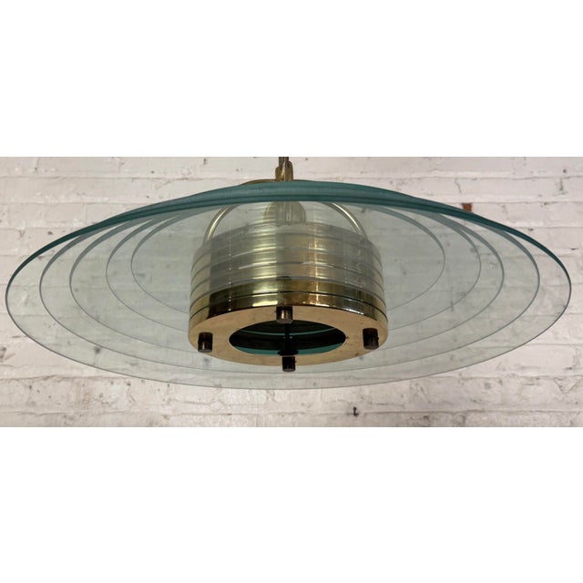 Saucer style glass hanging pendant. Five round glass discs act as the shade for a single medium base socket. Accenting...