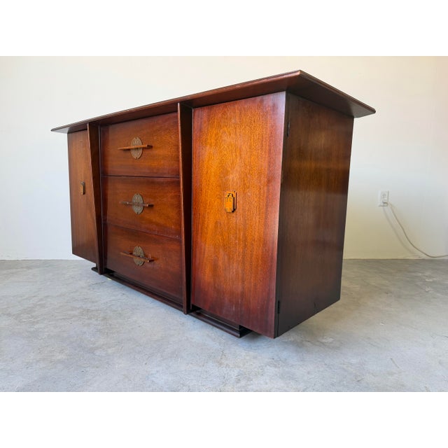 Striking vintage buffet/credenza crafted in rich mahogany, blending Art Deco elegance with Asian-inspired design elements....