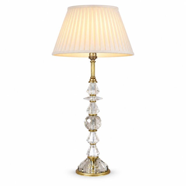 French table lamp dating to the 1950s, with a column of stacked faceted clear glass elements separated by slender brass...