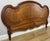 An elegant Antique French wooden footboard in walnut, distinguished by its sweeping curved profile, warm finish, shaped...