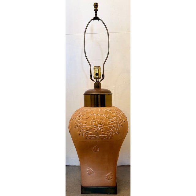 Vintage terracotta table lamp. It features a distinct relief design—a raised decorative pattern—consisting of a floral...