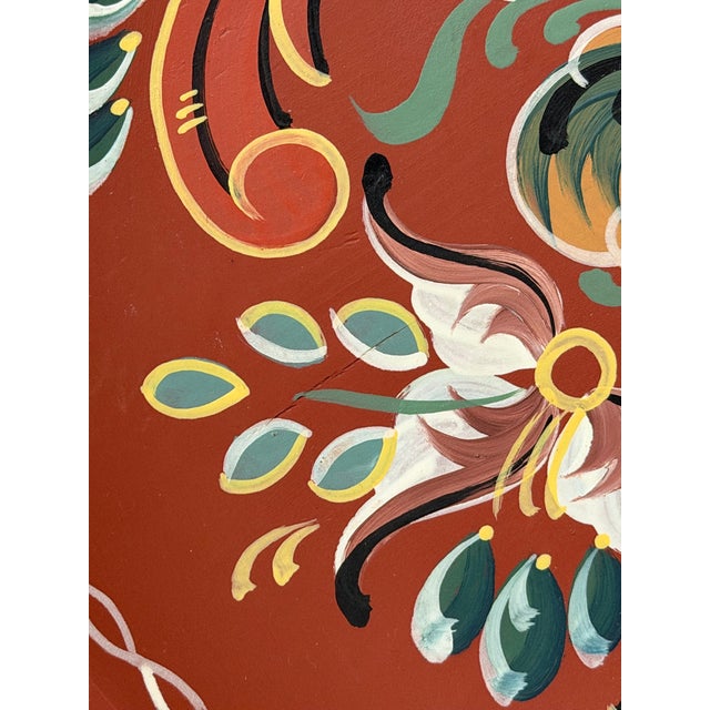 A beautifully hand‑painted Norwegian rosemaling plate featuring traditional floral and foliate motifs in rich tones of...