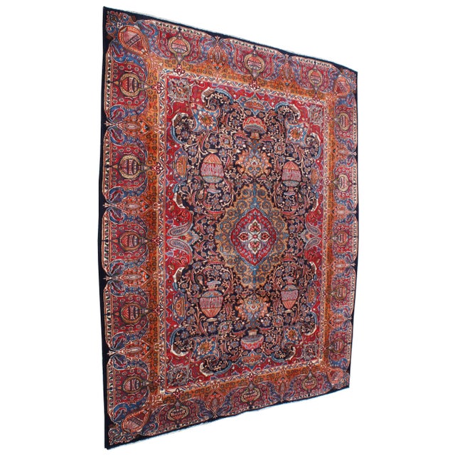 Antique hand knotted Persian rug featuring a field of reds and blues with ornaments, trophy urns / vases, various birds...