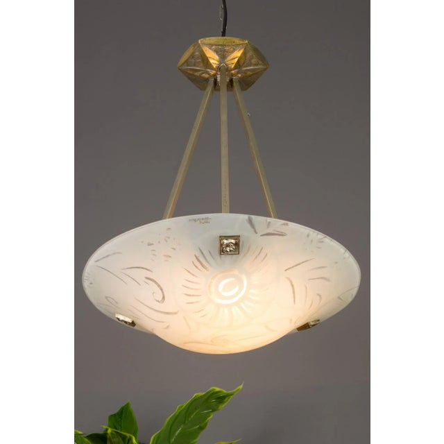 A charming art deco pendant light by maxonade verrier d’art, paris, with stylized floral pattern decoration. The drawing...