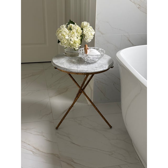 Elegant Mid-20th century Italian gueridon or side table featuring a thick solid Carrara marble top set into a gilt faux...