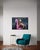 This artwork depicts a surreal scene where an astronaut cradles a figure draped over a vibrant pink flamingo float. The...