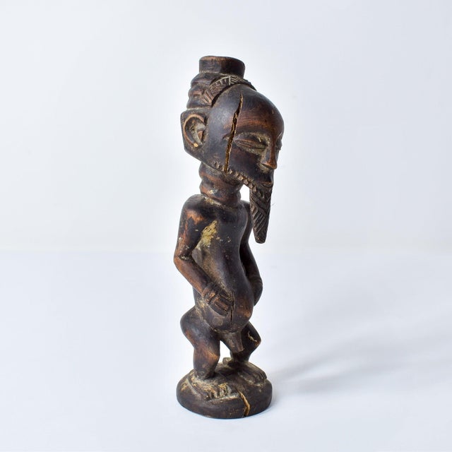 Hand-carved wood Kusu figure with distinct body markings and influence from their Songye and Hemba neighbors. This unique,...