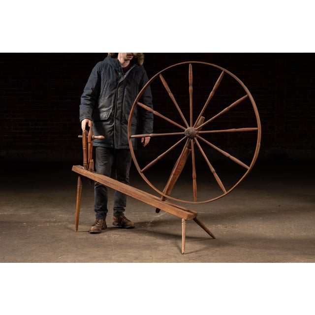 Large-scale wooden spinner's loom, commonly referred to as a walking wheel, used in hand-spinning wool and other fibers...
