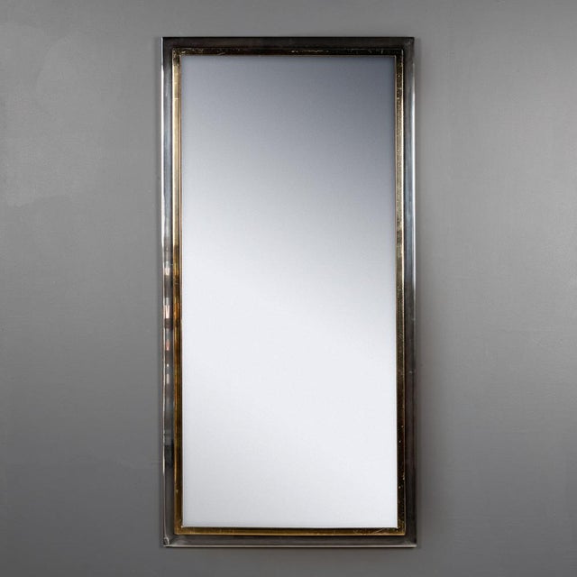 A 20th century belgo chrome white metal and brass-framed mirror featuring classic 1970s smoked glass. A stylish and...