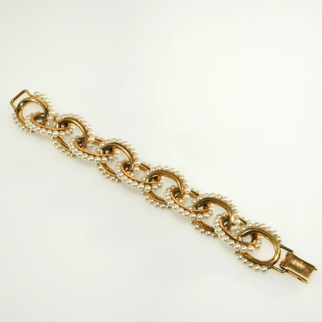 Vintage bracelet made with gold-plated links embellished with simulated pearls. This unique piece of early 1960s jewelry...