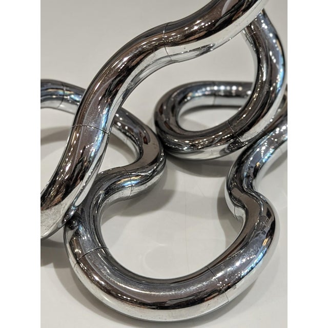 Chrome-finished Tangle sculpture designed by Richard X. Zawitz, one of the most recognizable explorations of interactive...