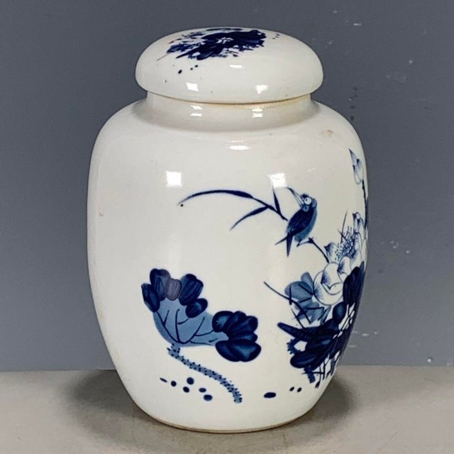 This is a charming vintage porcelain tea jar, decorated in the classic blue and white palette. The jar features a rounded,...