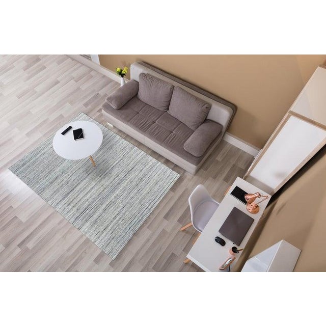 This gray wool rug is a hand knotted pile floor covering designed with a contemporary style. Originating from India, this...