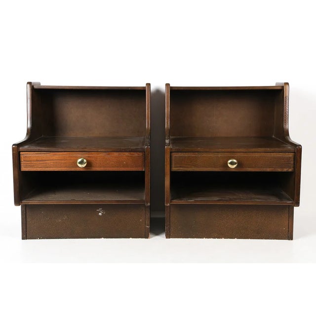 Pair of Danish nightstands crafted in oak, dating to the 1970s. Each nightstand features a single drawer with a brass-tone...