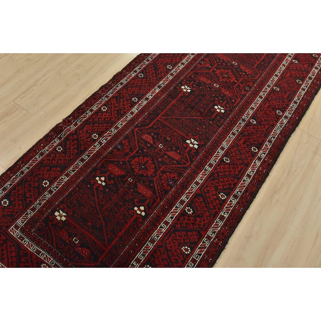 An authentic vintage tribal Baloch rug hand-knotted with fine wool and natural dyes. This oriental rug features geometric-...