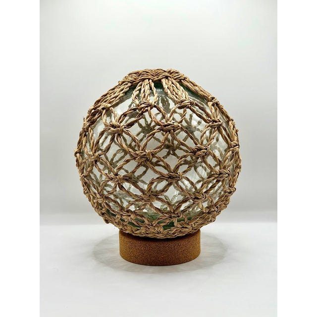 Beautiful netted glass fishing float style decor piece with a clear hand-blown look glass orb, natural woven rope netting,...