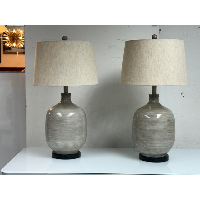 Design Plus Gallery presents Pair of Ceramic Table Lamps. Each lamp showcases a softly contoured bottle-form ceramic body...