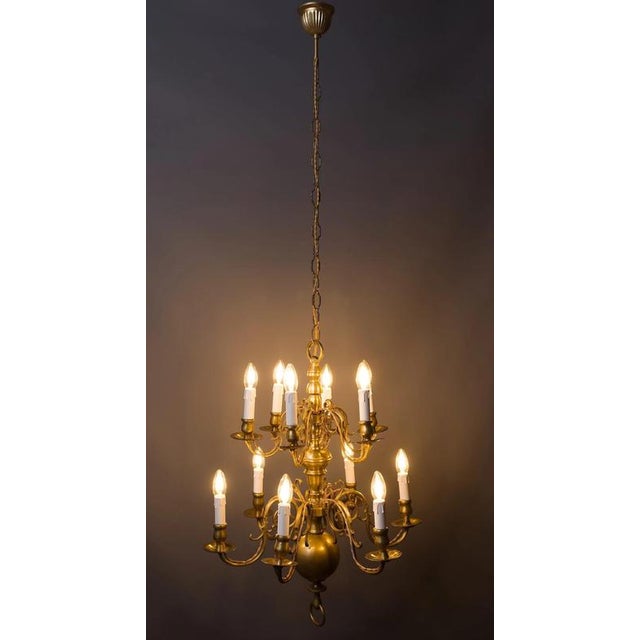 A magnificent cast brass chandelier from the 18th century, made in the Dutch style, with richly decorated arms and a...