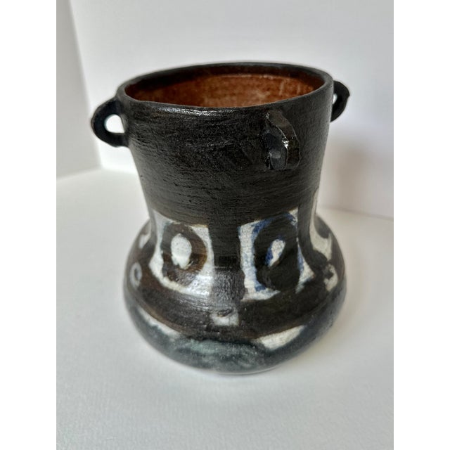 This eye-catching handmade vase combines a deep black finish with striking white abstract designs. The unique loop handles...