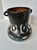 This eye-catching handmade vase combines a deep black finish with striking white abstract designs. The unique loop handles...