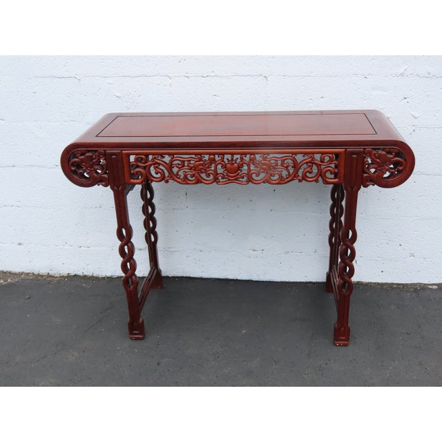 This stunning Console Table is made of ornately carved solid wood. It features a rectangular tabletop with inverted ends...