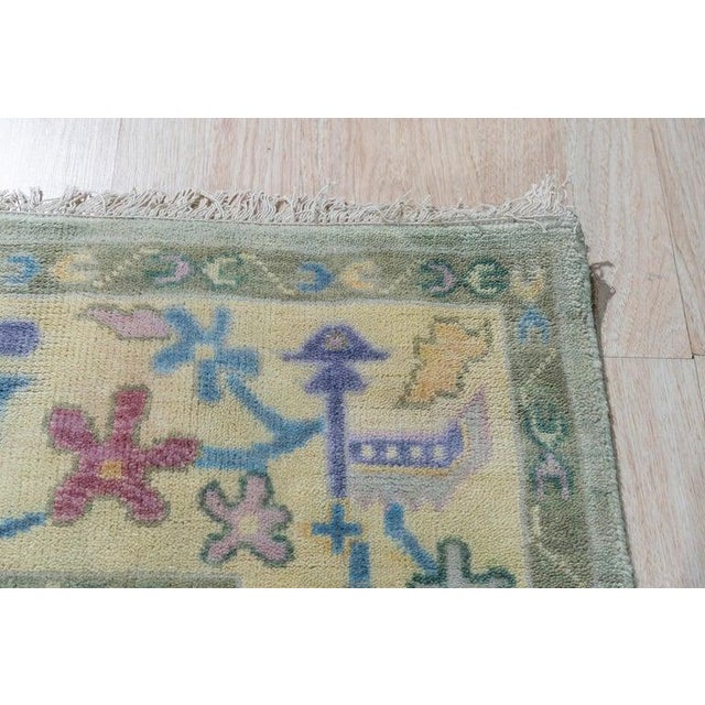 This green wool rug features a hand knotted pile weave construction, designed in the style of Agra rugs. Made in India,...